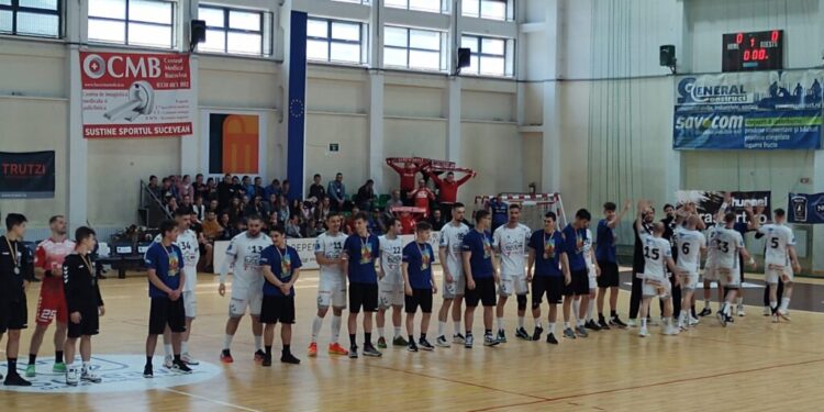 O onoare pentru juniorii medaliați ai Sucevei. Tinerii handbaliști, pe teren la începutul partidei dintre campioana României, Dinamo București, și CS Universitatea Suceava (FOTO)