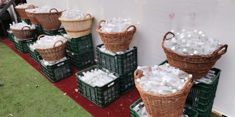 Sticle de jumătate cu agheasmă mare, aduse cu cărucioarele și coșărcile în curtea Mănăstirii ”Sf. Ioan”, oferite credincioșilor, după Sfînta Liturghie săvărșită de Înaltul Calinic (Foto)