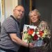 Șeful Inspectoratului Școlar Suceava, Ciprian Anton, cu un coș cu flori și cu o diplomă, la fosta lui învățătoare, Leontina Ciobanu, de Ziua Învățătorului